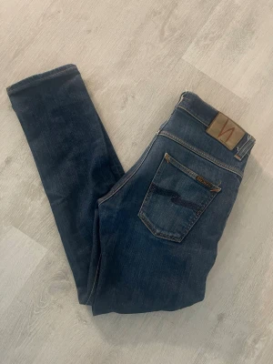 Nudie Jeans  - Säljer ett par mörkblå skinny jeans från Nudie Jeans i modellen Grim Tim