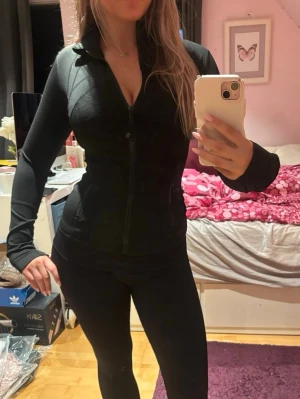 Lululemon Define jacket storlek 2 - Säljer min svarta Lululemon Define jacket storlek 2. använd 2 gånger. träningsset med figurnära passform. Jackan har dragkedja framtill, hög krage och långa ärmar. Byxorna är tighta och stretchiga, perfekta för gymmet eller löpning. Materialet känns mjukt och följsamt mot kroppen.