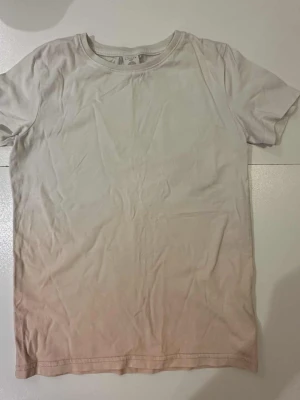 Vit och ljusrosa t-shirt strl 128 - Några väldigt små fläckar, se bild