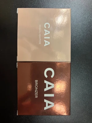 CAIA DUO Glow Bronzer (La Digue) + Highlighter (Saint Tropez)  - Glow Bronzer smälter in i huden med en silkeslen powder-to-cream-textur för en sömlös applicering. Bronzern är lättanvänd och en prisbelönt bästsäljare. Glow Highlighter smälter in i huden och ger en jämn finish med mjuk, naturlig lyster och kan appliceras för ett subtilt glow eller för mer effekt. Originalpris 790kr (duopris 655kr). Pris kan diskuteras. 