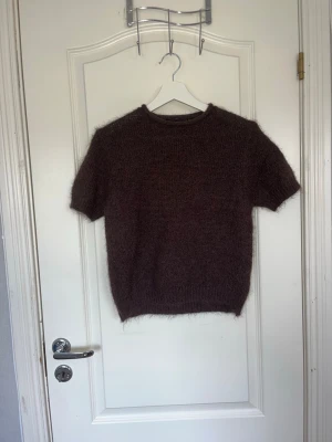 Brun stickad t-shirt - Helt oanvänd mysig brun stickad t-shirt med korta ärmar och rund hals.