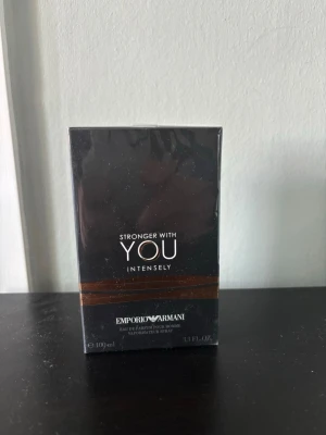 Stronger With You Intensely 100 ml - Emporio Armani Stronger With You Intensely är en parfym för honom i en elegant svart och brun förpackning. Flaskan rymmer 100 ml och doften är intensiv och modern, perfekt för dig som gillar exklusiva och maskulina parfymer.