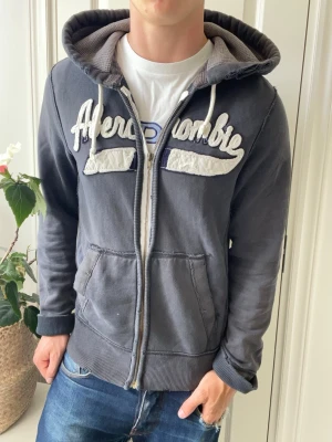 Abercrombie and fitch zip up  - Abercrombie and fitch zip up, sjukt snygg. Inga defekter förutom saknar en del i zipen, så man måste zippa ganska snabbt för att den ska zippa upp liksom! Modellen i bilderna är 180 cm 75 kg och bär Storlek s , Kom med frågor! 🌟 (Kan gå ned i pris vid köp av paket 😉) 