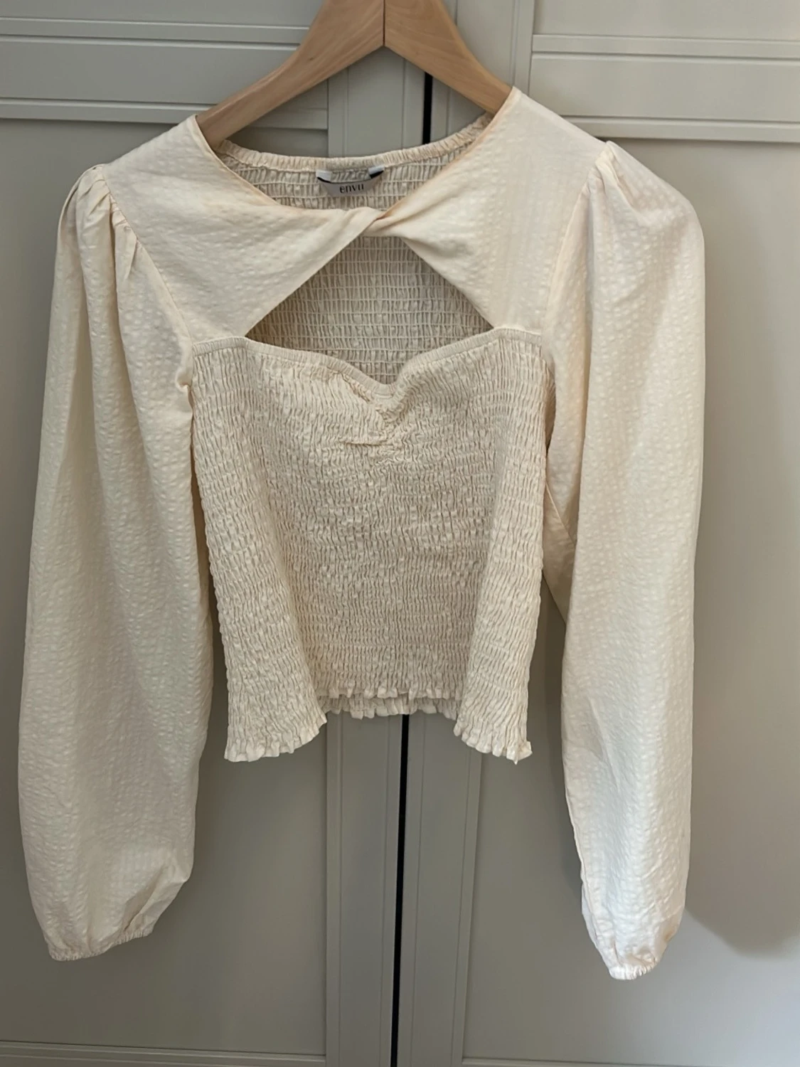 Krämvit blus med smock och cut-out