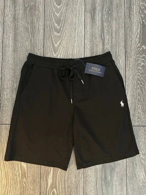 Svarta shorts från Polo Ralph Lauren - Svarta Ralph Lauren Shorts i bomull, riktigt sköna till sommaren ☀️. Storleken är M och det är därav jag säljer dem, fel storlek för mig. Men de är helt nya lappar sitter på. Bara att skriva vid funderingar 💬