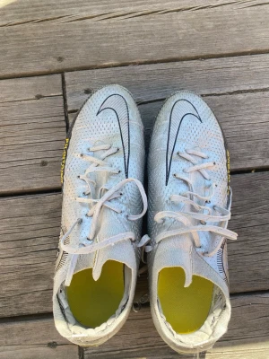Nike Elite storlek 41 - Säljer ett par vita Nike fotbollsskor med svart swoosh och gula detaljer. Skorna är en äldre model  och är sällsynta. Dessutom elite vilket är den högsta varianten på skon