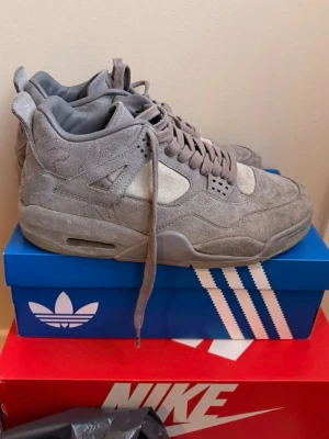 Gråa Air Jordan 4 x KAWS sneakers - Säljer ett par gråa Air Jordan 4 x KAWS sneakers i mocka. Köpta för längesedan, men använda bara ett par gånger. Slå ett PM för fler bilder, pris går att diskuteras