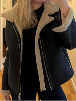 Svart teddyjacka - Perfekt jacka till våren, hösten och vintern! Supermysig med fluffigt material på insidan.