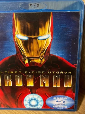 Iron Man Blu-ray 2-disc utgåva - Iron Man Blu-ray i ultimata 2-disc utgåvan. Omslaget har Iron Mans ikoniska röda och guld mask mot blå bakgrund. Innehåller extramaterial och HD-film. Perfekt för Marvel-fans som vill ha filmen i samlingen.