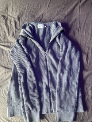 Fullzip East West - En grå, stilren fullzip från East West. Är i storlek S och är väldigt bekväm nu till hösten! Inga slitage eller hål, använd.