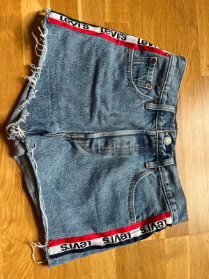 Levis 501 jeansshorts - Jeansshorts från Levis, modell 501. Strl 25. Midjemått tvärsöver ca 33,5 cm. 