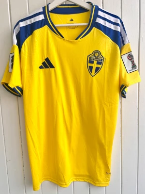 Sverige - VM 2026 - Fan version - Säljer den svenska VM 2026-matchtröjan. Tröjan är en reprint i nyskick. VM 2026-patches på ärmarna.      Storlek: Large (fan version så normal passform).  #Sweden #IFK #Worldcup #Allsvenskan #Fifa #Fotboll #AIK