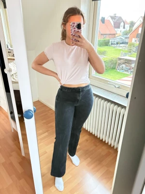 Svarta flare jeans med hög midja - Säljer ett par svarta jeans med utavängda ben och hög midja. Jeansen har klassisk femficksdesign och är i ett mjukt denimtyg som sitter snyggt på kroppen. Perfekta för en trendig och avslappnad look. Nypris 350kr