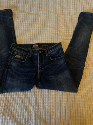 Mörkblå jeans från Superdry - Längd 107 cm Benöppning 17.5 cm Midja 42 cm