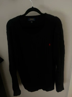 Svart stickad tröja från Polo Ralph Lauren - Svart stickad tröja från Polo Ralph Lauren som är riktigt stilig nu inför våren. Den är i ett mycket bra skick! Bara höra av er i dm vid ev frågor eller funderingar.