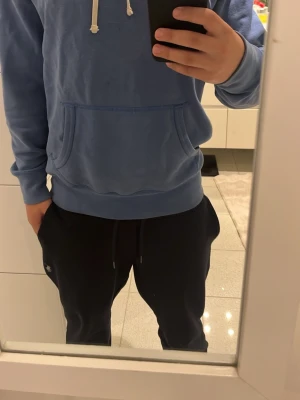 Blå hoodie från Polo Ralph Lauren - Snygg blå hoodie från Polo Ralph Lauren med klassisk känguruficka och vita snören.Storleken är S men den passar även XS. Liten grön logga broderad på bröstet. 