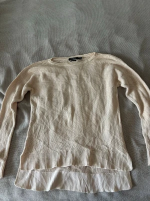 Beige stickad tröja Lauren Ralph Lauren - Säljer en beige stickad tröja från Lauren Ralph Lauren Denim. Tröjan har rund hals, långa ärmar och ribbstickade detaljer vid nederkant och ärmslut. Materialet är mjukt och strukturerat, med en extra slät panel längst ner för en cool look.