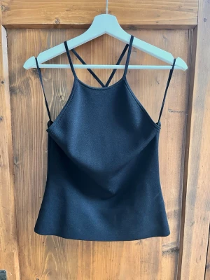 Svart linnetopp - Snygg svart linnetopp med tunna, korsade axelband i ryggen. Så fin, storlek s💕