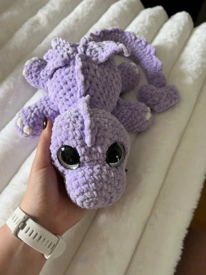 Virkad lika drake - Detta är en urgullig ljus lila drake, virkat med mjukt garn från Hobbii som heter Baby Snuggle💜✨🫶🏼 Den har hårda silvriga ögon som inte går att ta av, sitter som bergen💜 Den är cirka 60 cm lång när man sträcker ut svansen✨Och längtar efter sitt för alltid hem🥹💜 