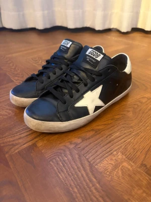 Golden goose skor - Säljer dessa svarta golden goose skor i mycket bra skick på grund av att de blivit för små. Vid köp får du även med skobox och dustbag. Storlek: 42. Priset är diskuterbart.