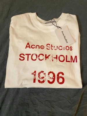 Acne studio tröja  - Säljer min helt nya acne studio t shirt med vinröd/röd text på. Tröjan sitter bra och är gjort av lite tjockare tyg så att den passar perfekt till sommaren. PRISET GÅR ATT DISKUTERA!