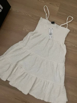 Vit sommarklänning med volanger  - Super söt volangklänning med en rosett upptill!💕Aldrig använd, nypris 399