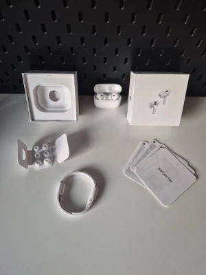 Apple AirPods Pro trådlösa hörlurar - Säljer ett par vita Apple AirPods Pro med laddningsetui, extra silikonpluggar, laddningskabel och originalförpackning. Hörlurarna är kompakta, har stilren design och levereras med allt som behövs för att komma igång direkt. Perfekt för dig dom vill ha ett par lurar som inte kostar skjortan. Billigare vid snabb affär