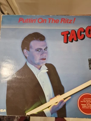 Taco Puttin’ On The Ritz vinylskiva - Taco Puttin’ On The Ritz vinylskiva. Albumet är utgivet på etiketten RCA och innehåller låtar som bland annat titelspåret "Puttin’ On The Ritz" samt flera andra spår listade på baksidan av omslaget. Format: LP/vinyl. Omslaget visar artistfoto på fram- och baksida samt låtlista på baksidan.