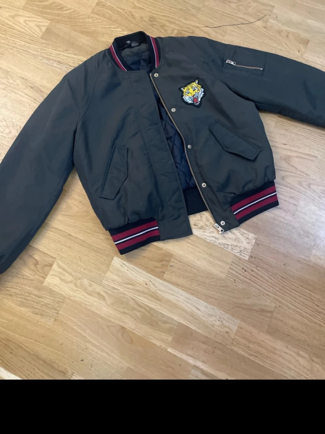 Svart bomberjacka med tigerpatch