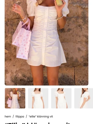 Vit kort puffärmad klänning Filippa - Söt vit kortklänning från Filippa med puffärmar och knappar framtill. Klänningen har en figurnära passform, fyrkantig urringning och lätt rynkade detaljer längs bröstet. Perfekt för sommarens alla tillfällen.