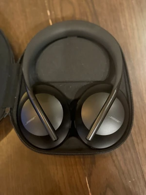 Bose Noise Cancelling Headphones 700 - Snygga svarta Bose Noise Cancelling Headphones 700 med modern design och mjuka öronkuddar. Trådlösa over-ear hörlurar i matt svart plast och metall, levereras med original hårt fodral. Perfekta för musik, gaming eller resor. Priset är ej hugget i sten, pris kan diskuteras. Nypris- 6000kr