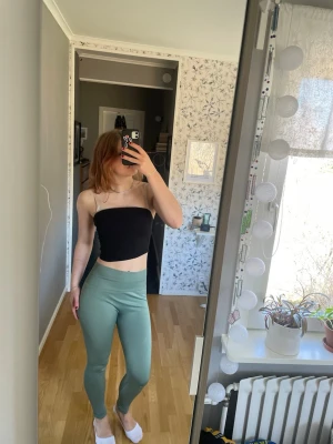 Gröna höga leggings - Snygga gröna leggings med hög midja och tight passform. Stretchigt material som sitter skönt och formar sig efter kroppen. Inga synliga loggor eller märken. Små hål på knäna men går lätt att sy över 