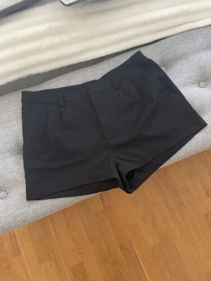 Svarta kostymshorts  - Svarta kostymshorts med midwaist passform och bälteshällor. Perfekta till sommaren och lätta att matcha med olika toppar🌸storlek 38/40