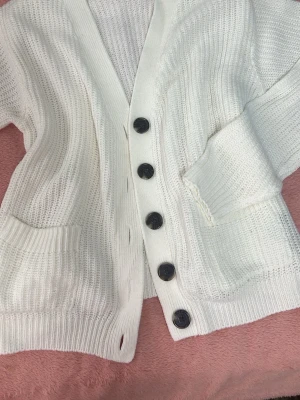Vit stickad kofta med stora knappar - Vit stickad kofta perfekt till sommaren och sena kvällar. Använd 2 gånger 