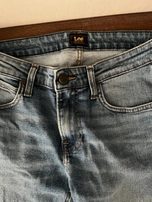 Ljusblå jeans från Lee - Snygga ljusblå jeans från Lee med klassisk femficksdesign och raka ben. Jeansen har en lätt tvättad look och är tillverkade i denim med synliga sömmar. Perfekta för en avslappnad stil.