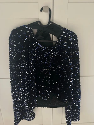 Paljettblus med rosett i ryggen - Använd två gånger