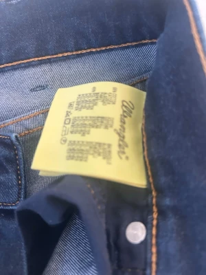 Wrangler blå jeans W28 L34 - Säljer ett par klassiska blå jeans från Wrangler, modell Jess. Jeansen har snygga kontrastsömmar och är tillverkade i slitstarkt denimtyg. Perfekta för dig som gillar tidlös stil och vill ha ett par jeans som funkar till det mesta.
