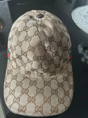 Gucci keps (äkta) - Jag säljer en beige guccikeps i bra skick som passar perfekt till en vardagsanvändning även till lite uppklädda outfits. Nypris går för 4500 kr+