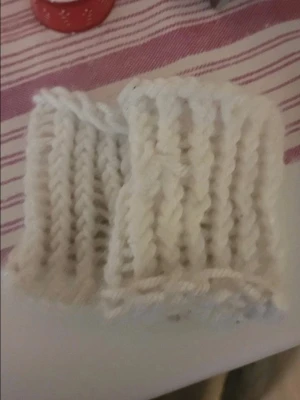 Vita stickade handledsvärmare - Ett par vita, ribbstickade handledsvärmare i mjukt garn. Perfekta för att hålla handlederna varma under kyliga dagar. Snyggt och enkelt tillbehör som passar till det mesta.