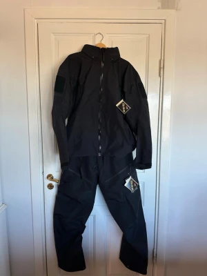 ARCTERYX LEAF ALPHA GEN 2 set, byxor och jacka helt nytt - Arc’teryx LEAF / Pro Alpha 2 set. Jacka och byxor. Endast testat. Helt nytt. Säljs på grund av fel storlek.  Nypris 15 800 kr. Inga plagg som någonsin hamnar på rabatt.  Hemsidor som terräng kräver militär-ID vid köp. Säljs inte till privatpersoner vanligtvis, så nu har du chansen.  Gore-Tex Pro. Extrem slitstyrka. Låg vikt. Byggt för hårda miljöer och operativ användning.  Högsta nivån av skalkläder. Best of the best.