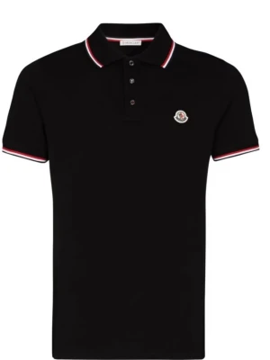 Svart Moncler pikétröja med rödvit kant - Klassisk svart pikétröja från Moncler med korta ärmar och krage. Tröjan har rödvita detaljer på krage och ärmslut samt Monclers logotyp på bröstet. Perfekt till jeans eller shorts för en clean look.