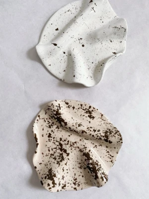 Handgjordt smyckesfat i beige - Unikt handgjordt fat i beige färg med bruna stänk och vågig, organisk form. Perfekta som dekoration eller förvaring av småsaker. Handgjorda och konstnärliga, varje fat har sitt eget uttryck. GÄLLER ENDAST ETT FAT Denna säljs till ett lägre pris då finishen skiljer sig något – men lika fin att använda ✨