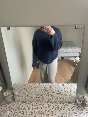 Mörkblå oversized stickad tröja - Mysig mörkblå stickad tröja med oversized passform och långa ärmar. Tröjan har en enkel design utan synliga detaljer eller mönster, perfekt för en avslappnad stil.