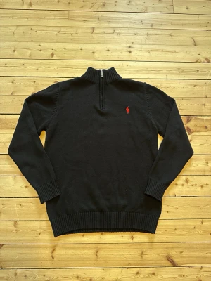 Ralph Lauren half zip - Aldrig använd, nyskick, storlek L men den sitter som en S modell. Bilder på mått kan fås 👍🏼Klassisk svart stickad tröja från Ralph Lauren i nyskick med halvzip och ribbad krage. Tröjan har långa ärmar, ribbade muddar och den ikoniska röda loggan broderad på bröstet. Perfekt för en stilren och avslappnad look. 