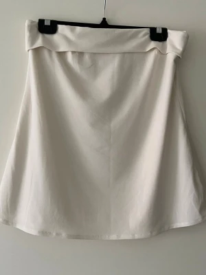 Vit bandeu topp  - Stilren vit bandeu top. Toppen har en enkel och clean design, perfekt för en avslappnad och trendig look. Passar till många olika outfits och är lätt att matcha.