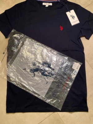 T-shirt från U.S. Polo Assn. - Hej! Säljer en snygg mörkblå t-shirt från U.S. Polo Assn. i storlek S. Tillverkad i mjuk bomull. Helt ny och originalförpackning finns. Perfekt till sommaren för en snygg och enkel stil. Har även en i storlek L vid intresse. Tveka inte att höra av dig vid frågor!