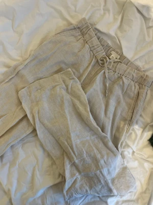 Beiga linnebyxor från Arket - Säljer ett par beiga linnebyxor från Arket med avslappnad passform och snörning i midjan. Byxorna har resår i midjan och sidofickor, perfekta för en chill och stilren look. Materialet är 100% linne vilket gör dem svala och sköna. Nypris - 800kr. Skriv vid frågor och pris kan diskuteras!💕💕