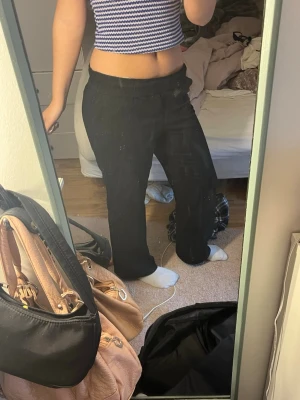 Svarta kostym/mjukbyxoe med rak passform - Säljer ett par svarta kostym/mjukisbyxor med rak passform och bred resår i midjan. Perfekta för en enkelare, stilren look. Materialet är mjukt och bekvämt, vilket gör dem riktigt sköna att ha på sig.