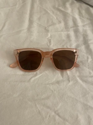 Solglasögon  - Ett par solglasögon i rosa 