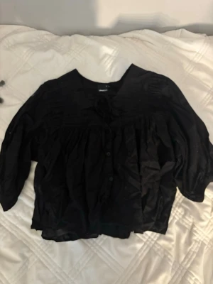 Svart blus från Gina Tricot - Säljer en svart blus från Gina Tricot med knappar framtill och lös passform. Blusen har trekvartsärm och rund halsringning. Perfekt nu till vår och sommar. Pris kan diskuteras💞